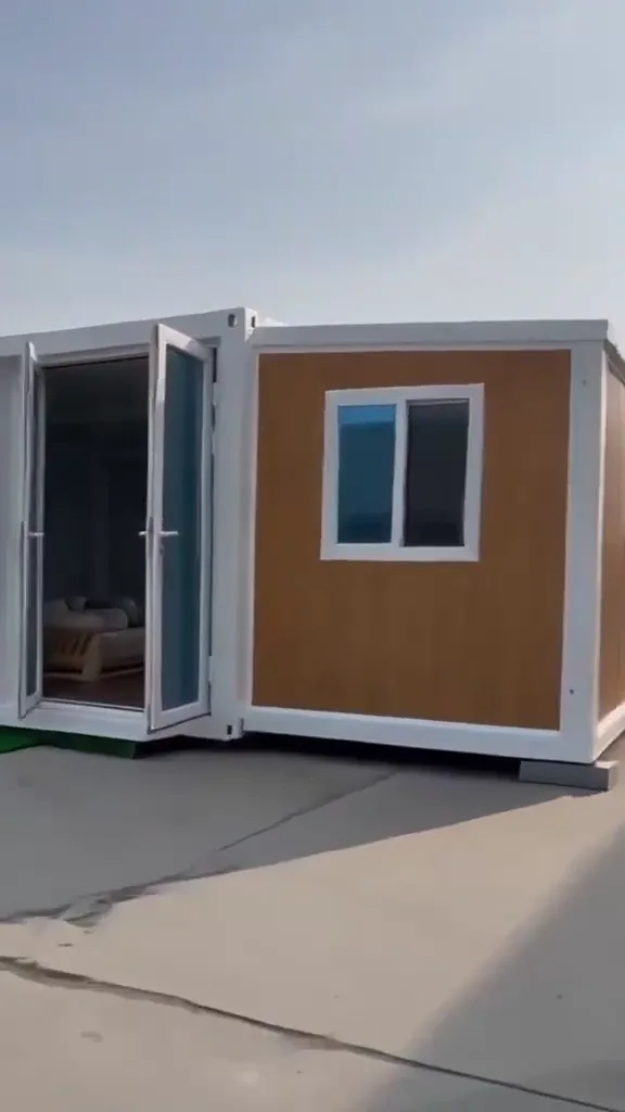 A fully unfolded THiNQ unit with glass doors open, on a concrete yard
